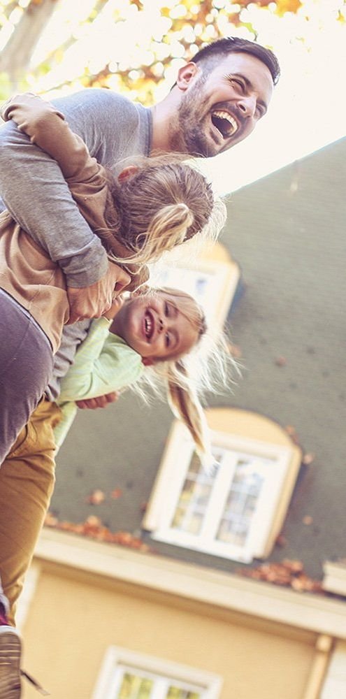 A family playing in front of their home